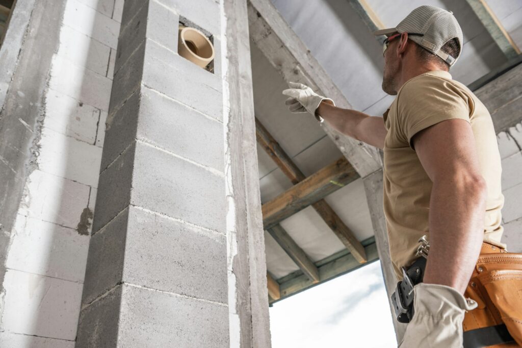 Pro Bricklayer Worker Pointing on a Chimney Segment