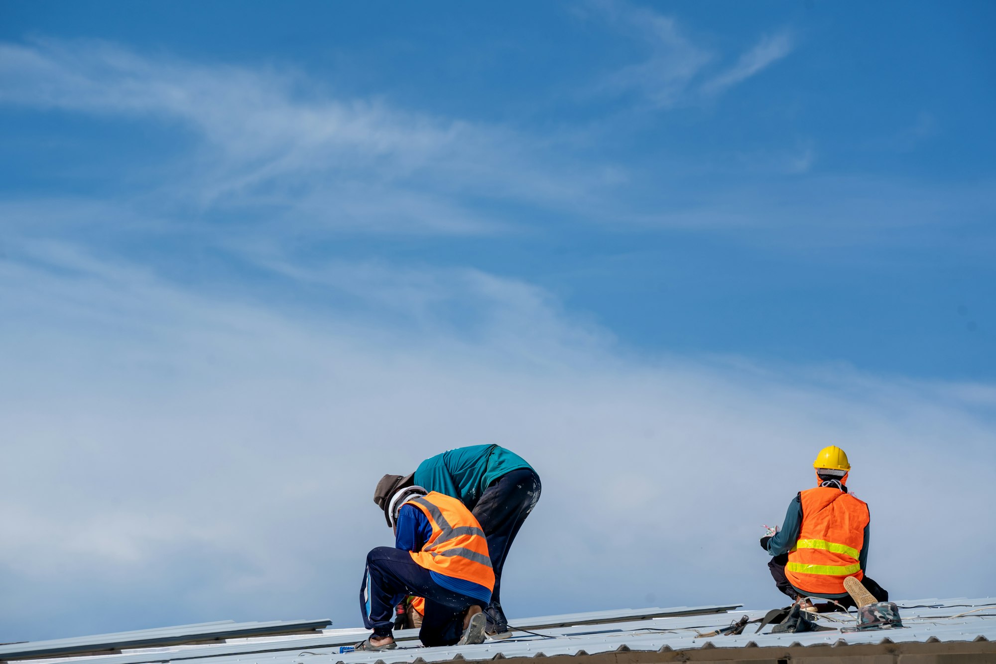 Roofer working at metal profile roof installation,Roofing tools,Electric drill used on new roofs.