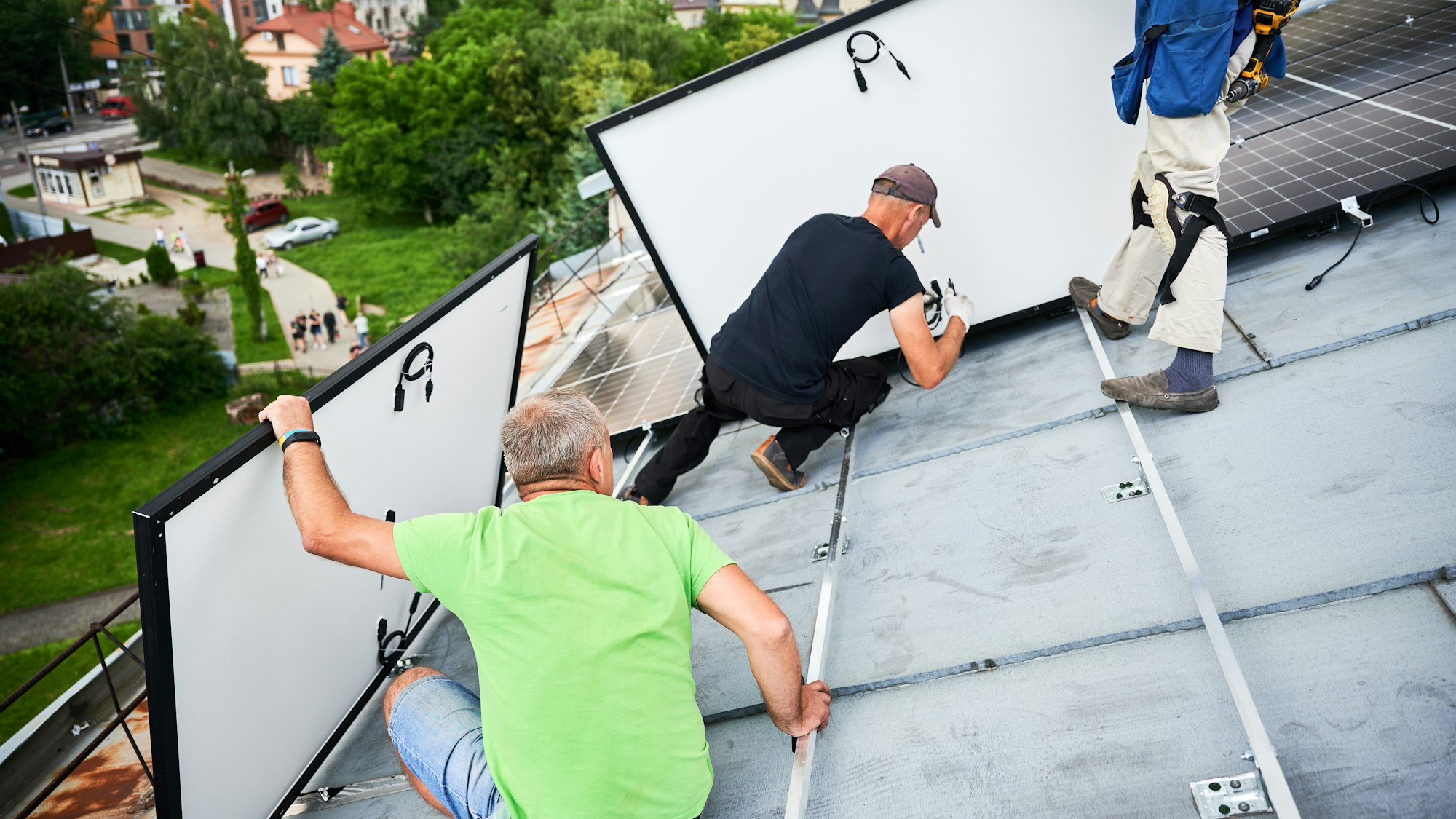 Workers building solar panel system on roof of house. Men installing photovoltaic solar module