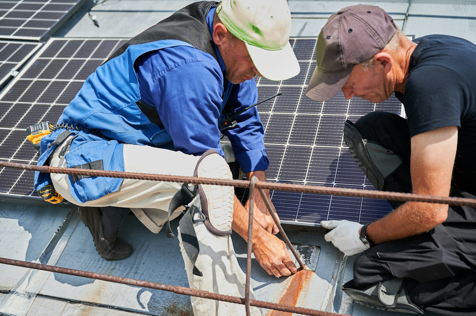 Workers building solar panel system on roof of house. Men installing photovoltaic solar module